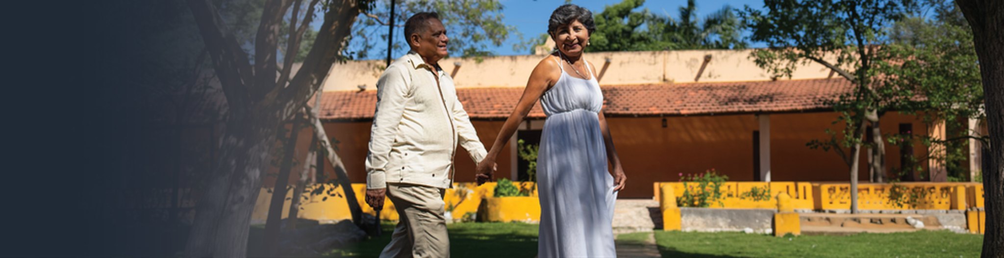 Photo of a retired couple smiling on a porch at sunset